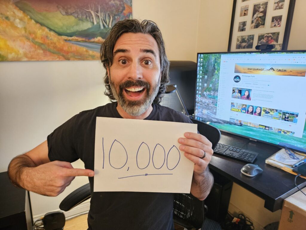 Picture of me happy holding a sign that says 10,000 subscribers.